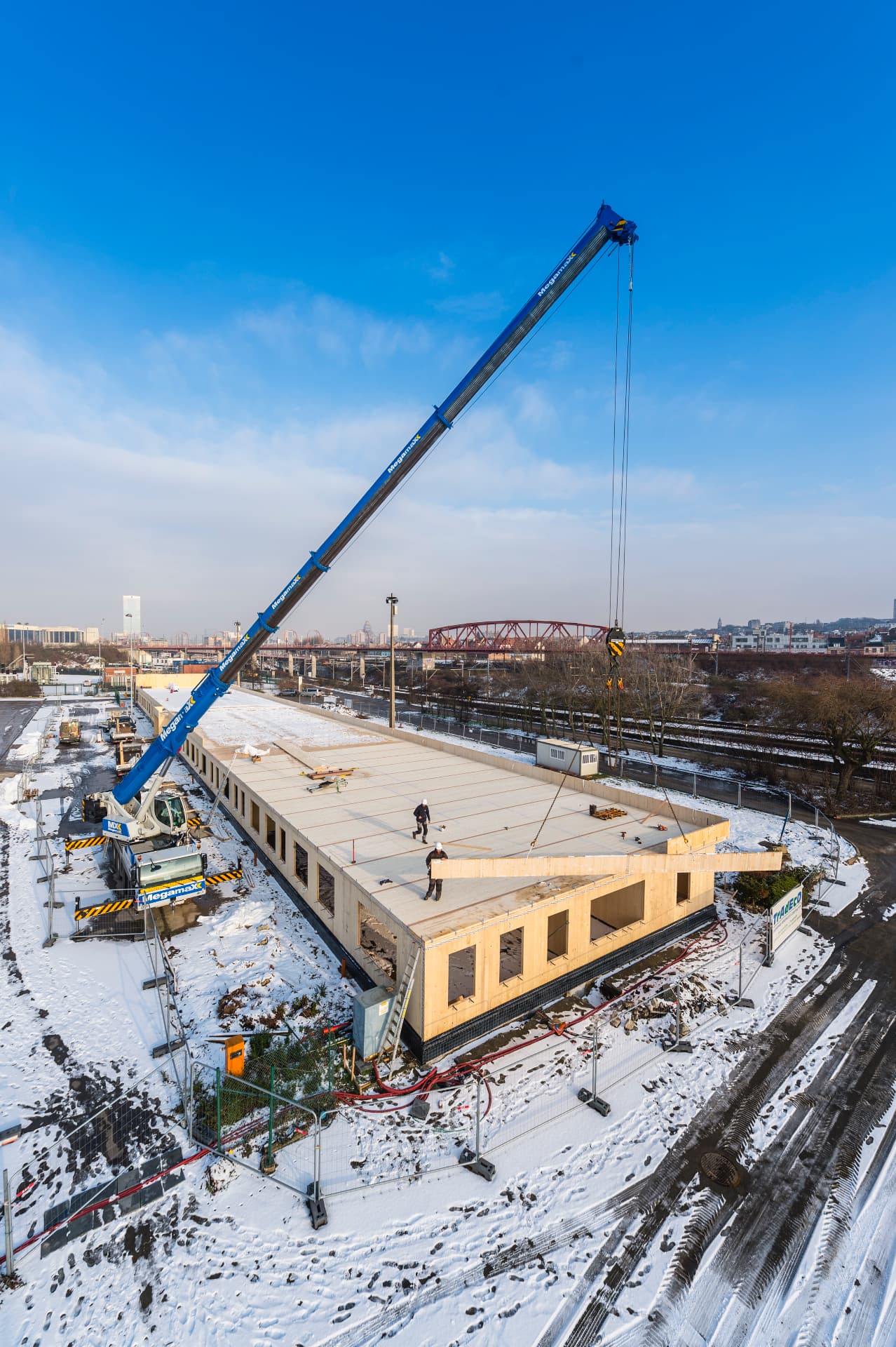 Montage van een houten gebouw met een hijskraan op de bouwplaats van BXL Formation